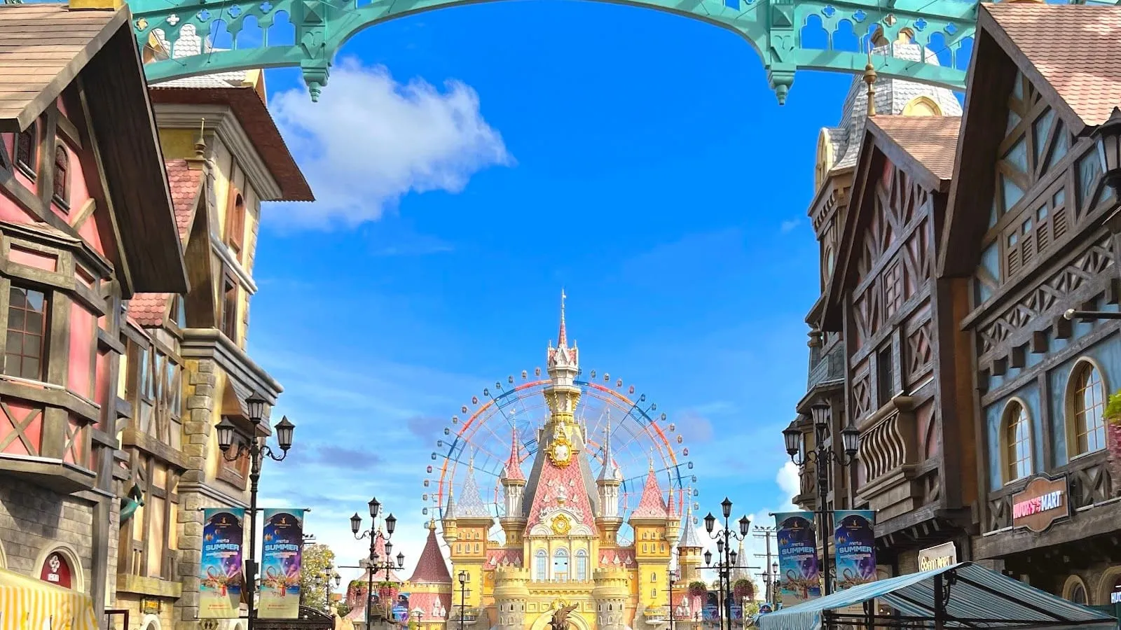 European-style shopfronts framing the fairy-tale castle and Ferris wheel at VinWonders Phu Quoc