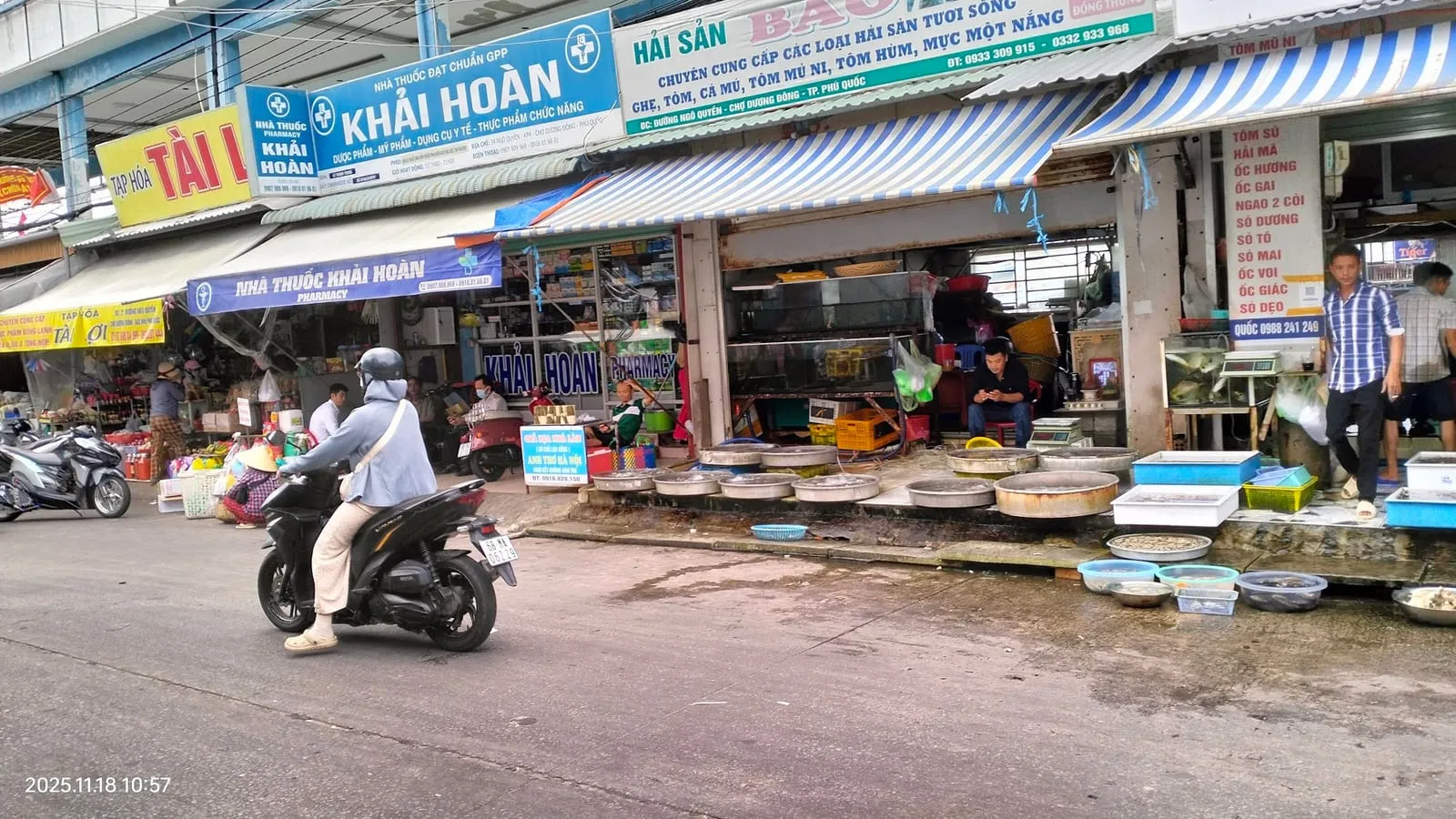 Shops and traffic on a street by Duong Dong market